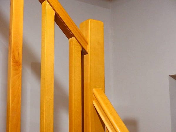 Rohové schody z masívneho dreva s robustným stredovým pilierom, ktorý fixuje zábradlie
